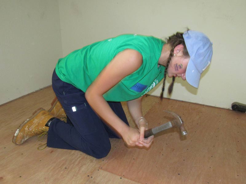 worker hammering flooring